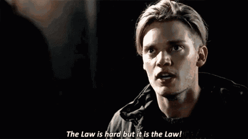 a man is talking to another man and saying the law is hard but it is the law .