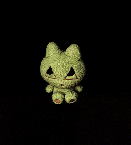 a stuffed animal that looks like a frog with a face cut out of it
