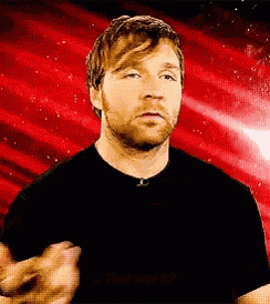 a man with a beard is wearing a black shirt and making a funny face .