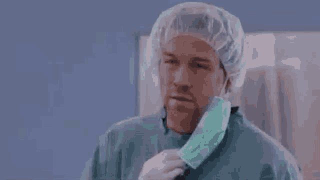 a surgeon wearing a surgical mask and a cap is asking but why .