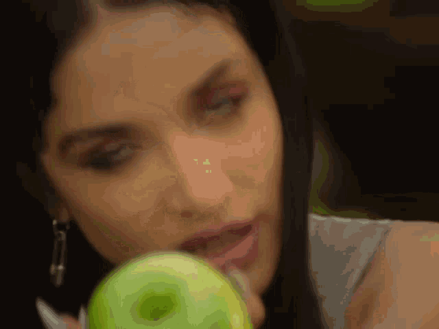 a woman is eating a green apple in a close up .