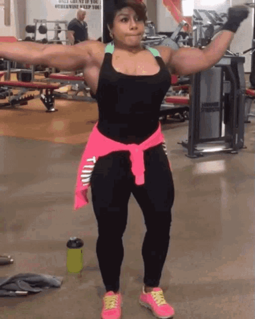 a woman in a gym with a pink shirt around her waist that says ' pink '