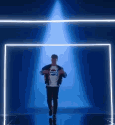 a man wearing a pepsi shirt is walking through a blue tunnel .