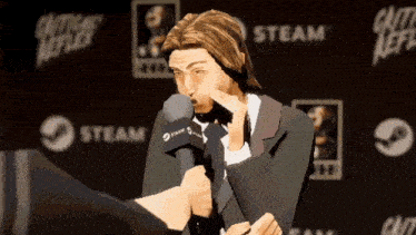 a man in a suit is talking into a microphone with a steam logo behind him