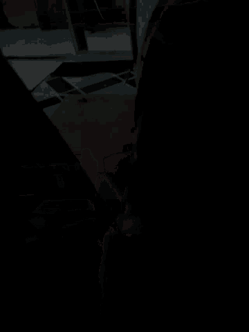 a person is standing in a dark room with a green tile floor
