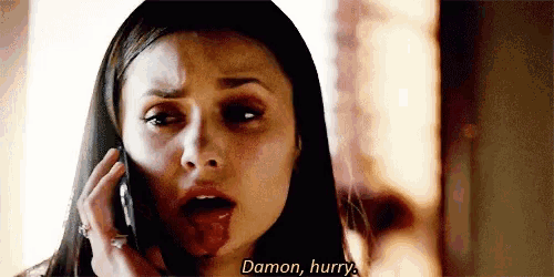 a woman with blood on her face is talking on a cell phone and says damon , hurry .