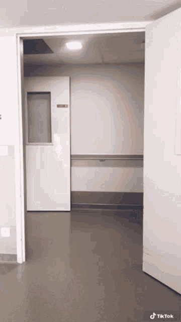 a hospital hallway with a door that is open and a sign that says exit