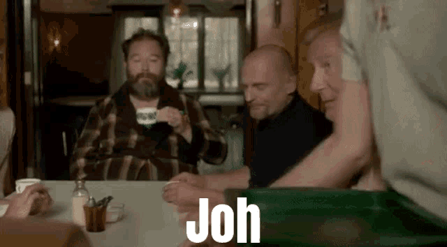 a group of men are sitting at a table with the word joh written on it