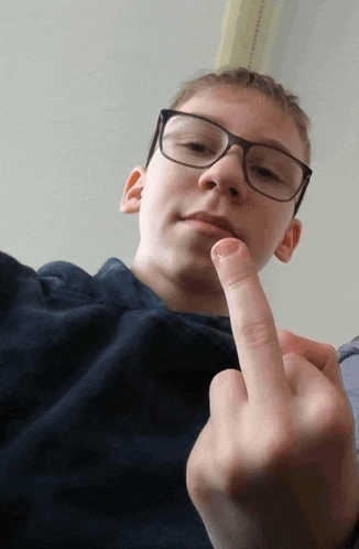 a young boy wearing glasses is making a middle finger gesture
