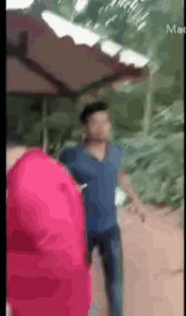 a man in a blue shirt is standing next to another man in a red shirt