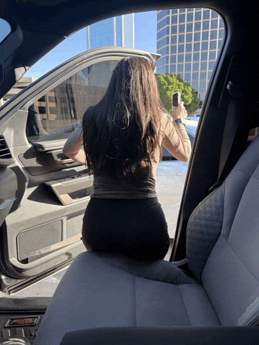 a woman is taking a picture of herself in a car