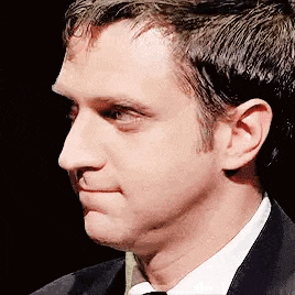 a man in a suit and tie is making a face .