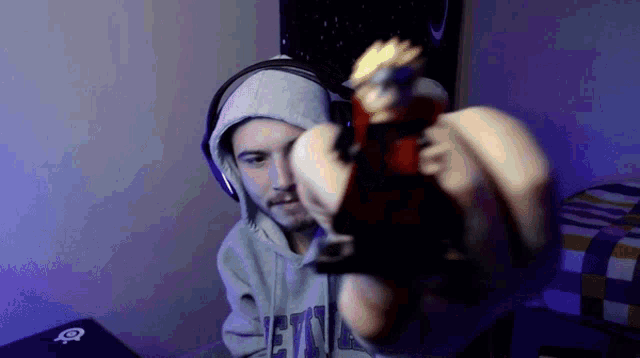 a man wearing headphones and a grey hoodie with the word jets on it