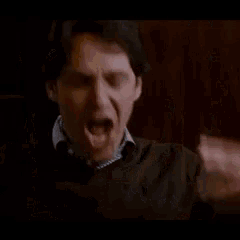 a man in a blue shirt is talking to another man in a room .