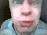 a close up of a man 's face with glasses on and a blurred background .