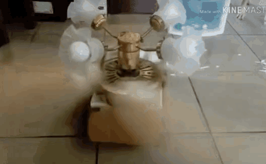 a ceiling fan is sitting on a tiled floor with smoke coming out of it