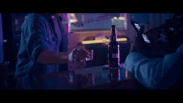 a man in a gremlin costume is holding a bottle of beer