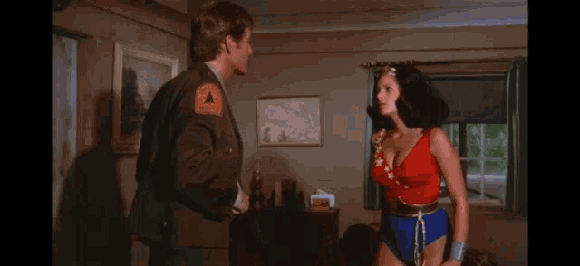 a woman in a wonder woman costume is being held by a man .