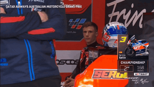 a man wearing a helmet with the number 03 on it stands in front of a motorcycle