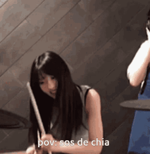 a woman playing drums with the words pov : sos de chia above her
