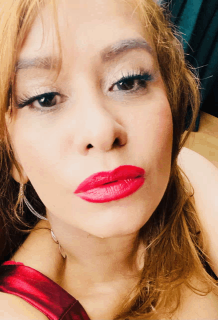 a close up of a woman 's face with red lipstick on her lips