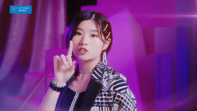 a woman is giving the middle finger in a purple room .