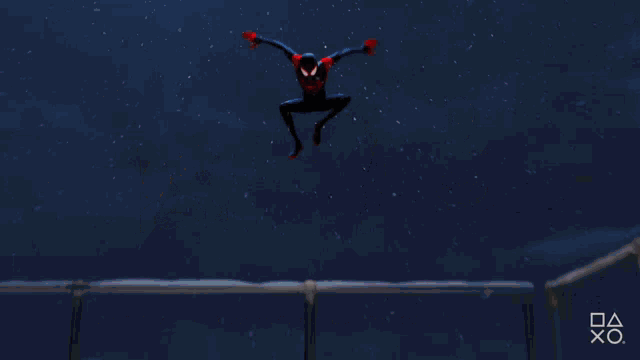a man in a spiderman suit is holding a rope in a room
