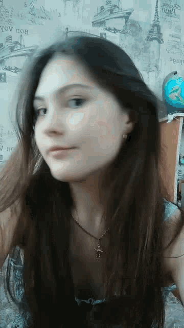 a girl taking a selfie in front of a wall that says " you " on it