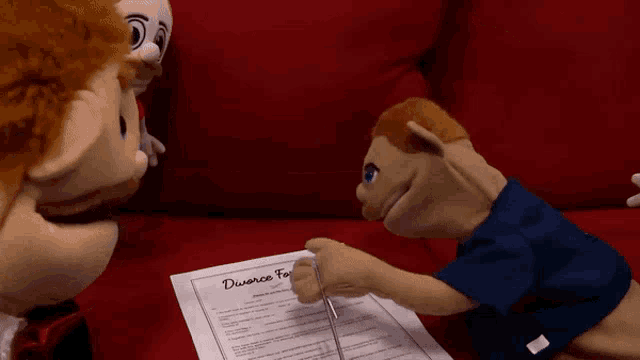 a puppet is cutting a divorce form in half