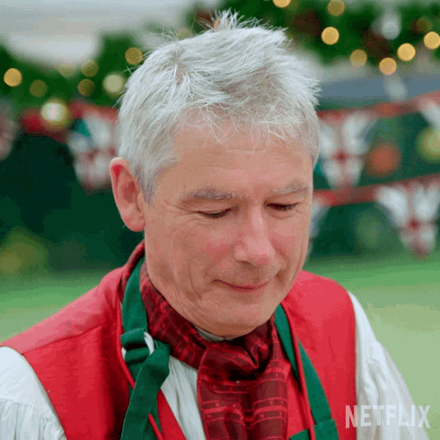 a man wearing a red vest and green scarf with a netflix logo on the bottom