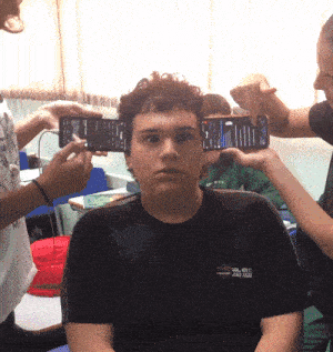 a boy wearing a black shirt that says ' col est ' on it is being photographed