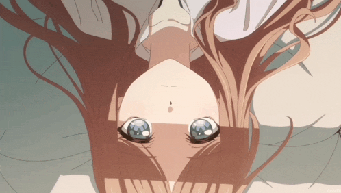a close up of a girl 's face with blue eyes and a white shirt