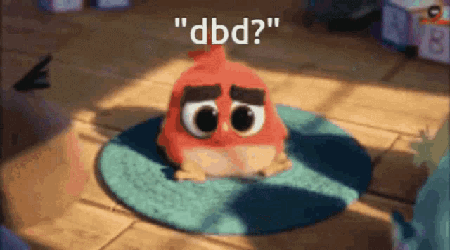 a red angry bird is sitting on a blue rug with the words " dbd " written above it .