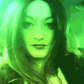 a woman 's face is shown in a pixelated image with a green background