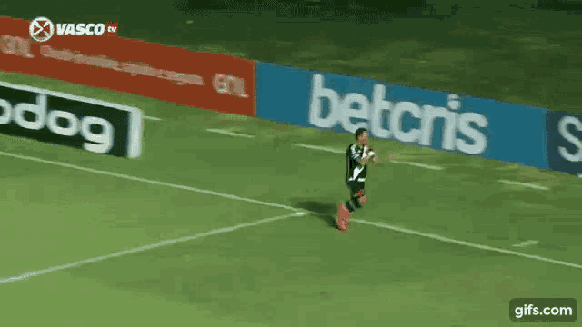 a soccer player runs across the field in front of a betcris banner