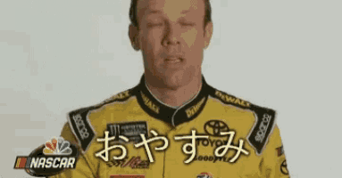 a man wearing a yellow nascar uniform with his eyes closed .