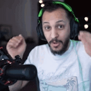 a man with a beard is wearing green headphones and making a funny face .