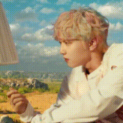 a man in a white shirt is sitting in front of a lamp and looking out the window .