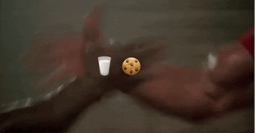 a man 's arm with a cookie and a glass of milk on it