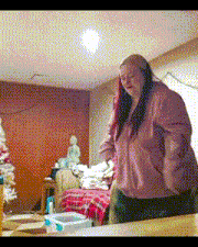 a woman in a pink jacket stands in a living room