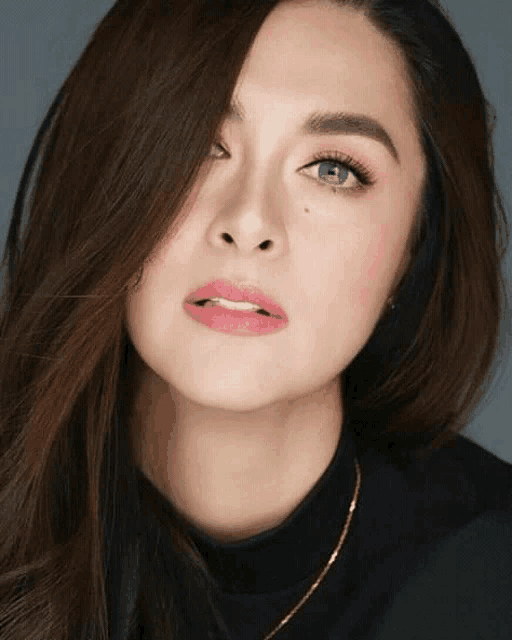 a close up of a woman 's face wearing a black turtleneck