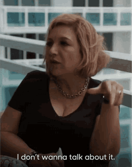 a woman sitting on a balcony says i don 't wanna talk about it