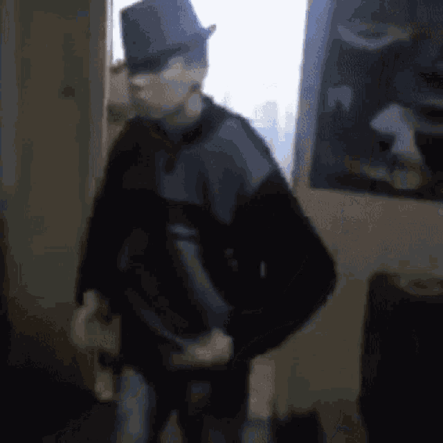 a man wearing a hat is standing in a dark room