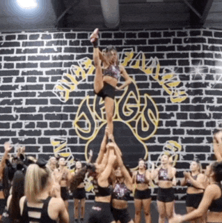 a group of cheerleaders are performing in front of a brick wall with the word jaguars written on it