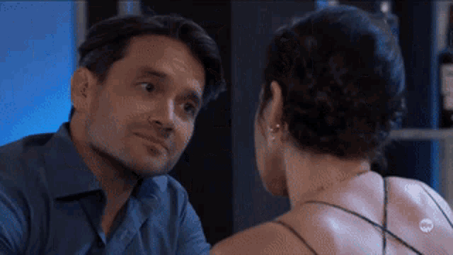 a man and a woman are looking at each other in a mirror .