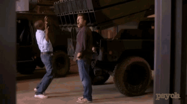two men are standing in front of a military vehicle with psych written on the bottom