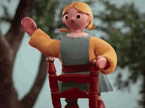 a cartoon doll is sitting in a red chair .