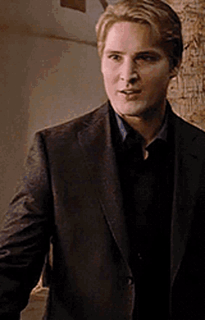 a man in a suit stands in a room