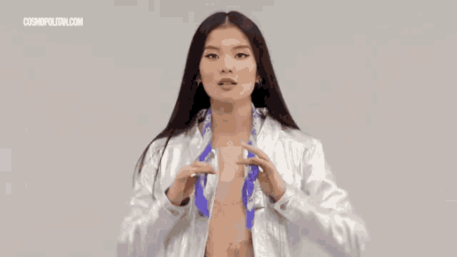 a woman is wearing a silver jacket and a blue scarf around her neck .