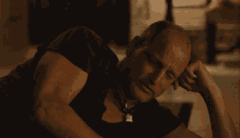 a man is laying on the floor holding a stack of money